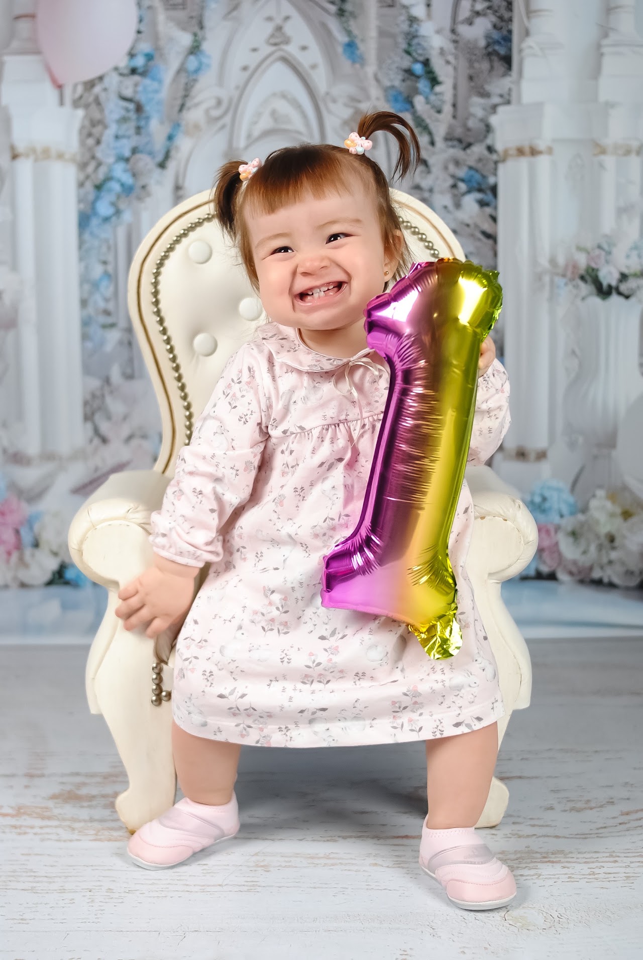 Nena con globo numero uno celebrando su primer año